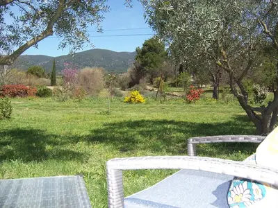two wicker benches sitting in a field of grass at OUSTAOU DU GAYET gîte de charme avec piscine privée in Lourmarin