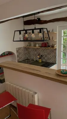 a kitchen with a counter and a red chair at La Maison de la Forge in Gordes