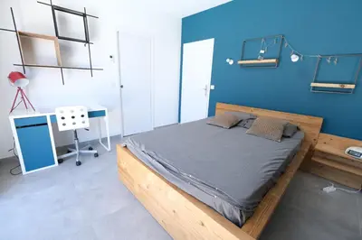 a bedroom with a wooden bed and a blue wall at LS6-408 ERNO Villa contemporaine avec piscine privée 8 couchages à Chateauneuf de Gadagne - Proche d’Avignon in Châteauneuf-de-Gadagne