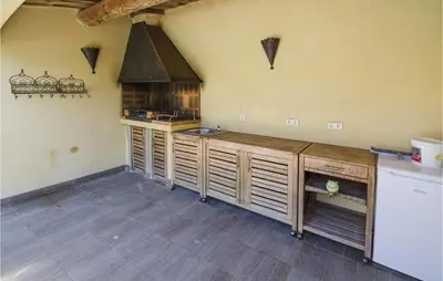 a kitchen with wooden cabinets and a stove at Amazing Home In Caumont Sur Durance in Caumont-sur-Durance