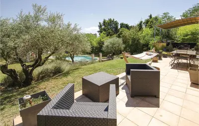 a patio with chairs and tables in a yard at Amazing Home In Caumont Sur Durance in Caumont-sur-Durance