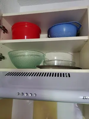 a shelf with bowls and plates on top of a refrigerator at Les demeures du Ventoux in Aubignan