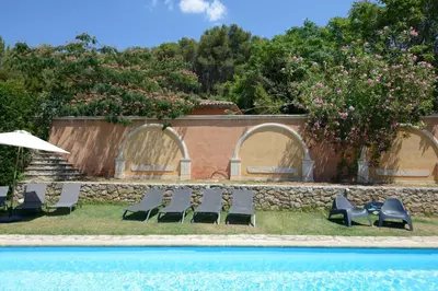 a group of chairs sitting next to a swimming pool at La Tour- Pigeonnier Provençal - Mas des Sous Bois in Ventabren