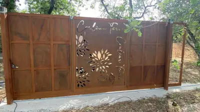 a wooden gate with flowers painted on it at Gite Couleur Terre à 10MN de Gordes in Croagnes