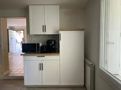 a kitchen with white cabinets and a microwave at Maison Provençale avec piscine in Carpentras