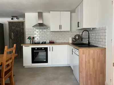a kitchen with white cabinets and a stove top oven at Maison Provençale avec piscine in Carpentras