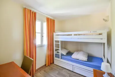 a room with two bunk beds and a desk at Les Maisons de Pont Royal en Provence - maeva Home - Maison climatisée pour 8 Personnes avec jardin privatif et terrasse MAE-2283 in Mallemort