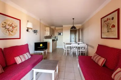 a living room with red couches and a kitchen at Les Coteaux de Pont Royal en Provence - maeva Home - Appartement 2 Pièces 4 Personnes - Confort MAE-5993 in Mallemort