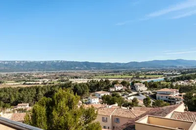 a view of a town with mountains in the background at Les Coteaux de Pont Royal en Provence - maeva Home - Appartement 2 Pièces 4 Personnes - Confort MAE-5993 in Mallemort