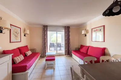 a living room with red couches and a table at Les Coteaux de Pont Royal en Provence - maeva Home - Appartement 3 Pièces 6 Personnes - Sélection MAE-6001 in Mallemort
