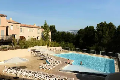 a large swimming pool with chairs and umbrellas at Les Coteaux de Pont Royal en Provence - maeva Home - Appartement 3 Pièces 6 Personnes - Sélection MAE-6001 in Mallemort