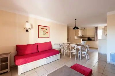 a living room with a red couch and a table at Les Coteaux de Pont Royal en Provence - maeva Home - Appartement 3 Pièces 6 Personnes - Sélection MAE-6001 in Mallemort