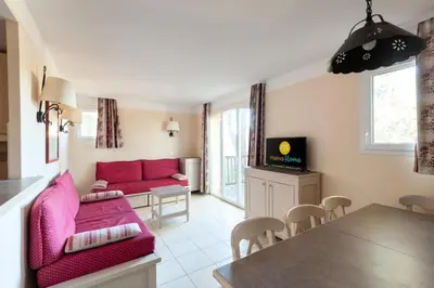 a living room with a pink couch and a table at Les Coteaux de Pont Royal en Provence - maeva Home - Maison 4 Pièces 8 Personnes - Budget MAE-6009 in Mallemort