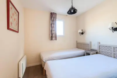 a room with two beds and a window at Les Coteaux de Pont Royal en Provence - maeva Home - Maison 4 Pièces 8 Personnes - Budget MAE-6009 in Mallemort