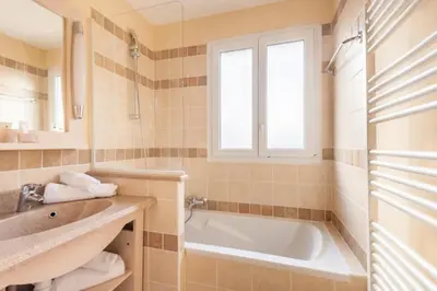 a bathroom with a tub and a sink and a window at Les Coteaux de Pont Royal en Provence - maeva Home - Maison 4 Pièces 8 Personnes - Sélection MAE-6014 in Mallemort