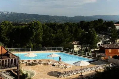 a large swimming pool with chairs and umbrellas at Les Coteaux de Pont Royal en Provence - maeva Home - Maison 4 Pièces 8 Personnes - Sélection MAE-6014 in Mallemort