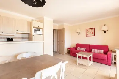a living room with a red couch and a table at Les Coteaux de Pont Royal en Provence - maeva Home - Appartement 2 Pièces 4 Personnes - Sélection MAE-6016 in Mallemort