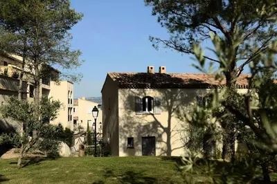 a large white building with trees in the foreground at Les Coteaux de Pont Royal en Provence - maeva Home - Appartement climatisé 2 Pièces 4 Personnes - Sélection MAE-6022 in Mallemort