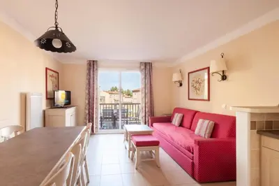 a living room with a red couch and a table at Les Coteaux de Pont Royal en Provence - maeva Home - Maison 3 Pièces 6 Personnes - Sélection MAE-8177 in Mallemort