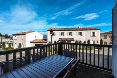 a balcony with a bench and buildings in the background at Les Coteaux de Pont Royal en Provence - maeva Home - Maison 3 Pièces 6 Personnes - Sélection MAE-8177 in Mallemort