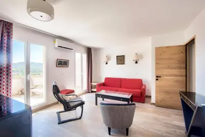 a living room with a red couch and a table at Les Coteaux de Pont Royal en Provence - maeva Home - Appartement 4 pièces 7 personnes - Prestige - super Home MAE-2094 in Mallemort