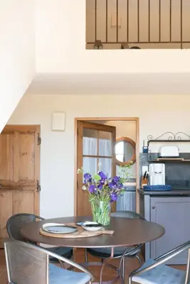 a kitchen with a table with a vase of flowers on it at Le Clos d'Estellan - Piscine chauffée in Bonnieux
