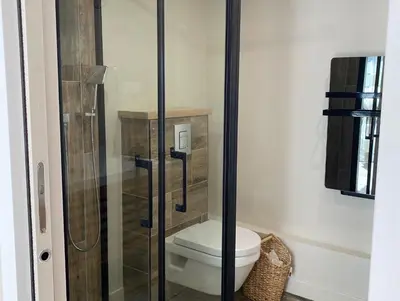a bathroom with a toilet and a glass shower at Instant Parfait en Provence Chambre privée et piscine in Monteux
