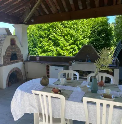 a table and chairs on a patio with a fireplace at Instant Parfait en Provence Chambre privée et piscine in Monteux