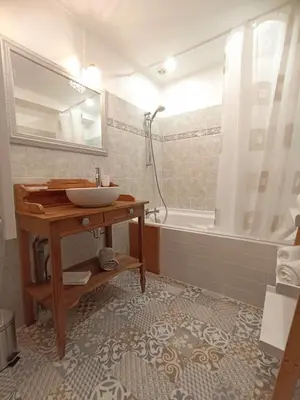 a bathroom with a sink and a tub with a mirror at Gite avec piscine 