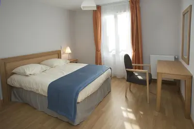 a bedroom with a bed and a desk and a table at Domitys Les Cigales du Lubéron in Cavaillon