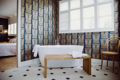 a bathroom with a tub and a table and a chair at Villa Amara in Aix-en-Provence