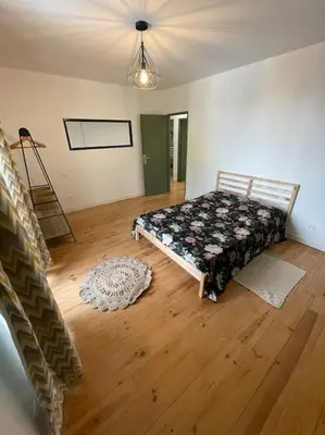 a bedroom with a bed and a wooden floor at Maison de charme avec piscine in Monteux