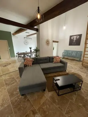 a living room with a couch and a table at Maison de charme avec piscine in Monteux