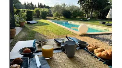 a picnic table with food and a glass of orange juice at Les cabanons de l'Oliveraie in Pernes-les-Fontaines