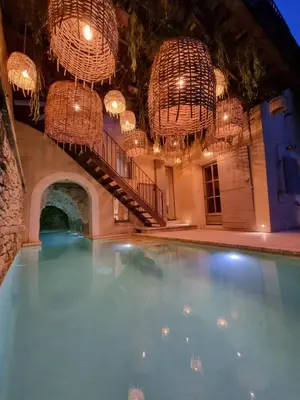 an indoor swimming pool with chandeliers and chandeliers at Maison au centre du village de Gordes avec vue incroyable in Gordes