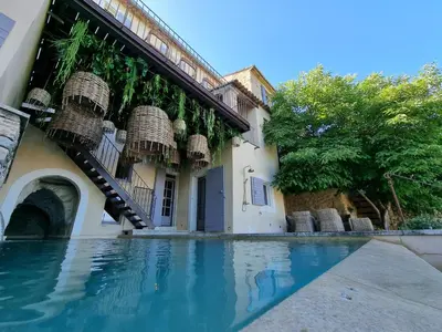 a building with baskets on the side of a swimming pool at Maison au centre du village de Gordes avec vue incroyable in Gordes