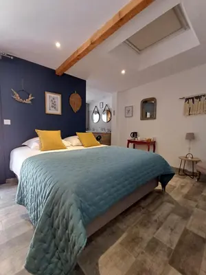 a bedroom with a large bed with yellow pillows at La Colinière, Chambre d'hôtes in Aix-en-Provence