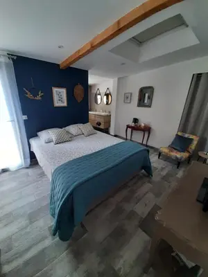 a bedroom with a bed and a blue wall at La Colinière, Chambre d'hôtes in Aix-en-Provence