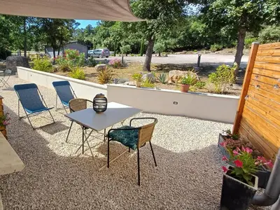 a patio with chairs and a table and a fence at La Colinière, Chambre d'hôtes in Aix-en-Provence
