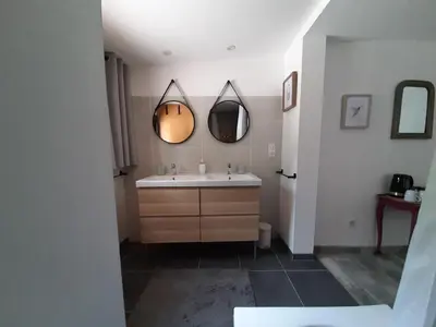 a bathroom with a sink and two mirrors at La Colinière, Chambre d'hôtes in Aix-en-Provence