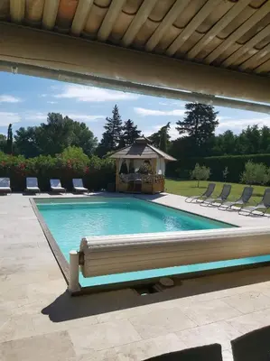 a large swimming pool in front of a house at La Plénitude in Le Thor