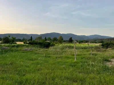 a field of green grass with mountains in the background at Cabanon bucolique face au Luberon in Lourmarin