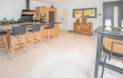 a kitchen with a counter and bar stools at Amazing Home In Robion in Robion en Luberon