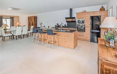 a kitchen with a large island with bar stools at Amazing Home In Robion in Robion en Luberon