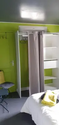 a bedroom with a bed and a window and a chair at Location saisonnière avec piscine et terrasse au pied du luberon in Lauris