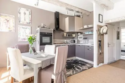 a kitchen and dining room with a table and chairs at Douceur sur la Sorgue in LʼIsle-sur-la-Sorgue