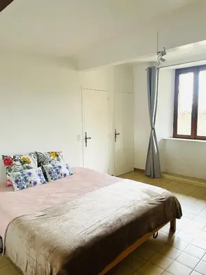 a bedroom with a large bed and a window at Maison LINA in Sault-de-Vaucluse