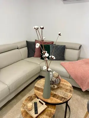 a living room with a couch and a table with flowers at Gîte l’Inattendu in Vachères