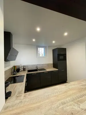 a kitchen with a black refrigerator and a sink at Gîte l’Inattendu in Vachères