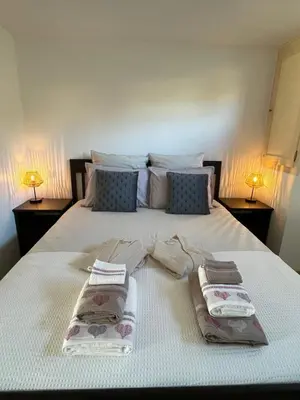 a bed with two towels on it with two lamps at Gîte l’Inattendu in Vachères